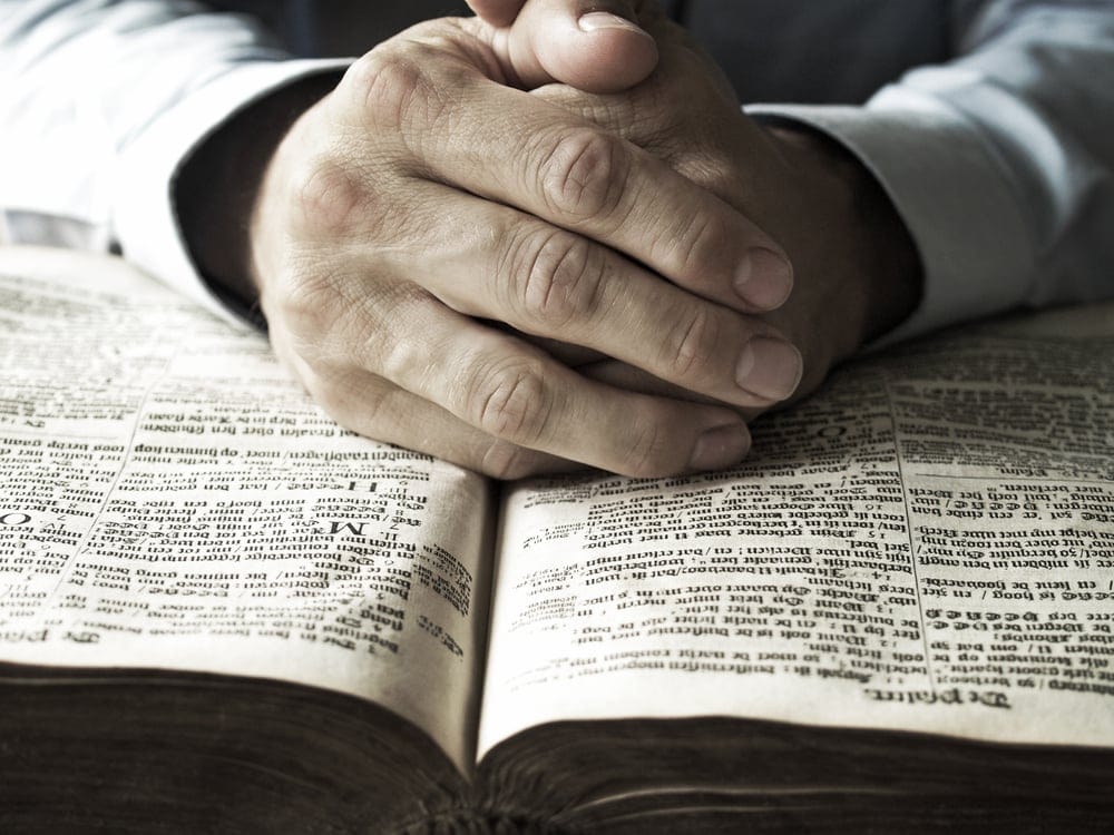 Man's hands on a bible.