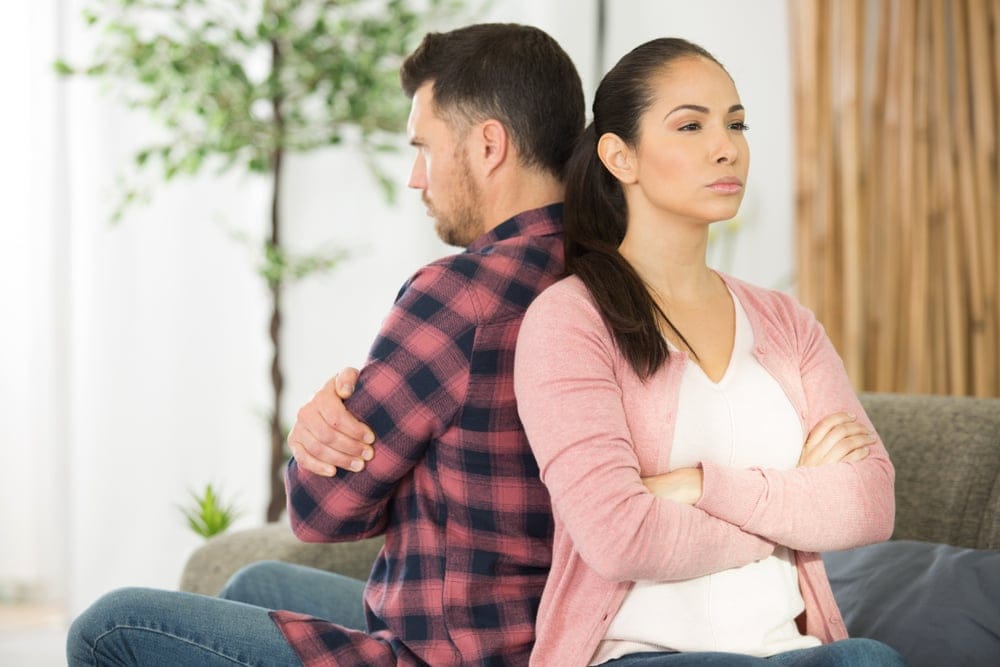 Couple sitting back to back.