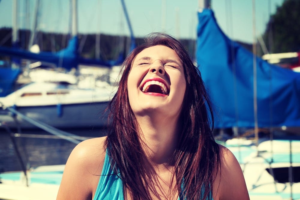Woman at marina laughing.