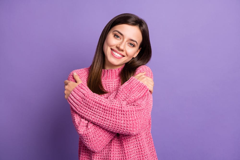 Woman giving herself a hug.
