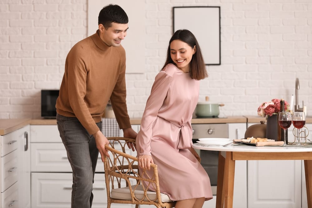 Man pulling the chair out for a woman.