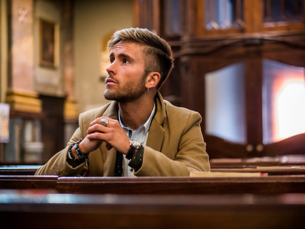 Young man sitting in church.
