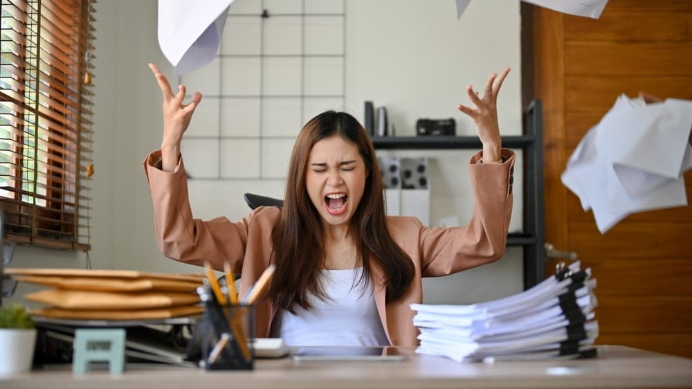 Furious young woman throwing her hands in the air.