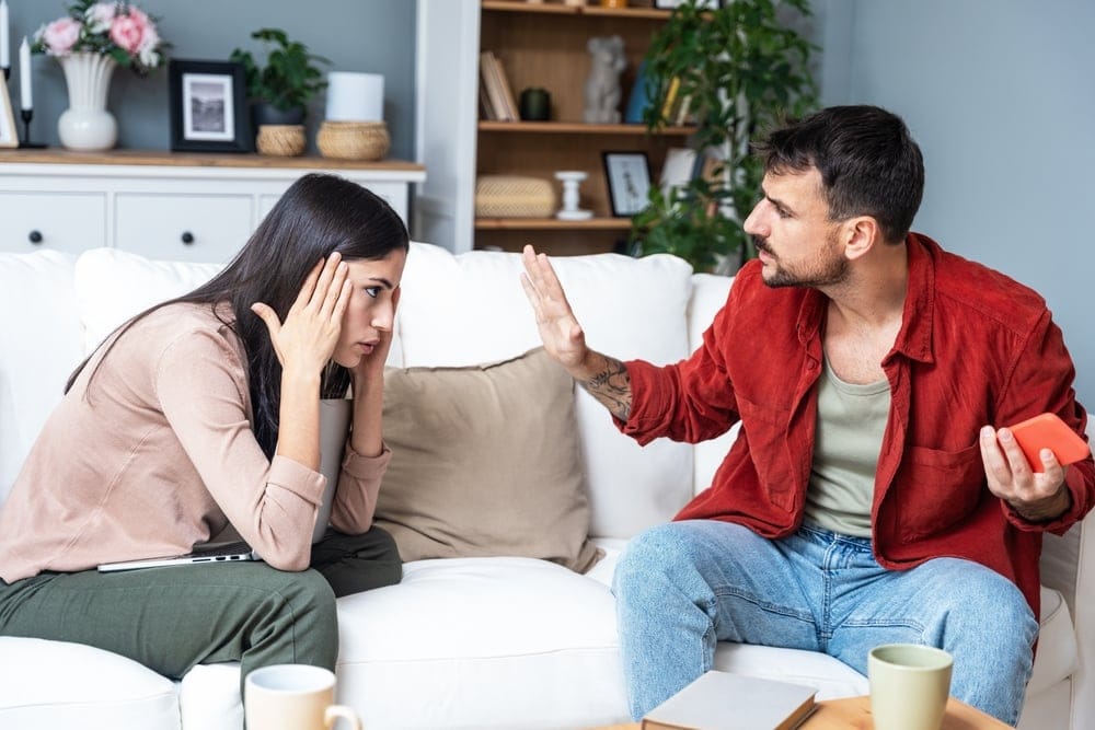 Couple arguing on the couch.
