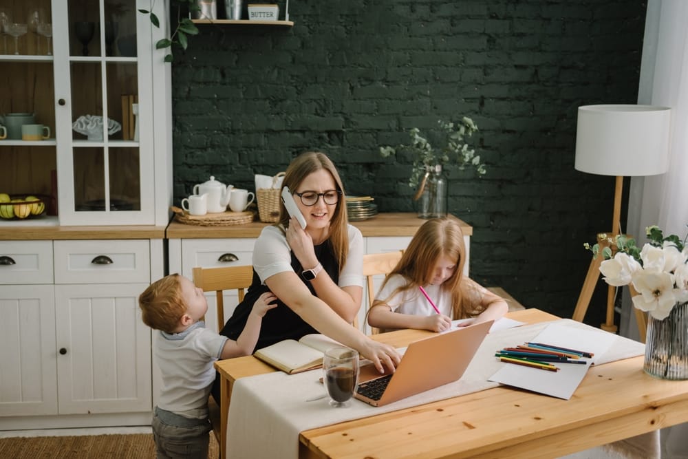 Busy mother with two young kids working and on the phone