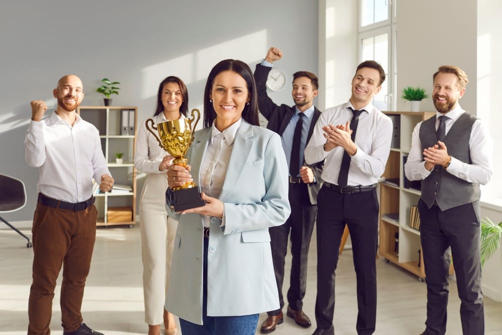 Woman smiling while holding a trophy.