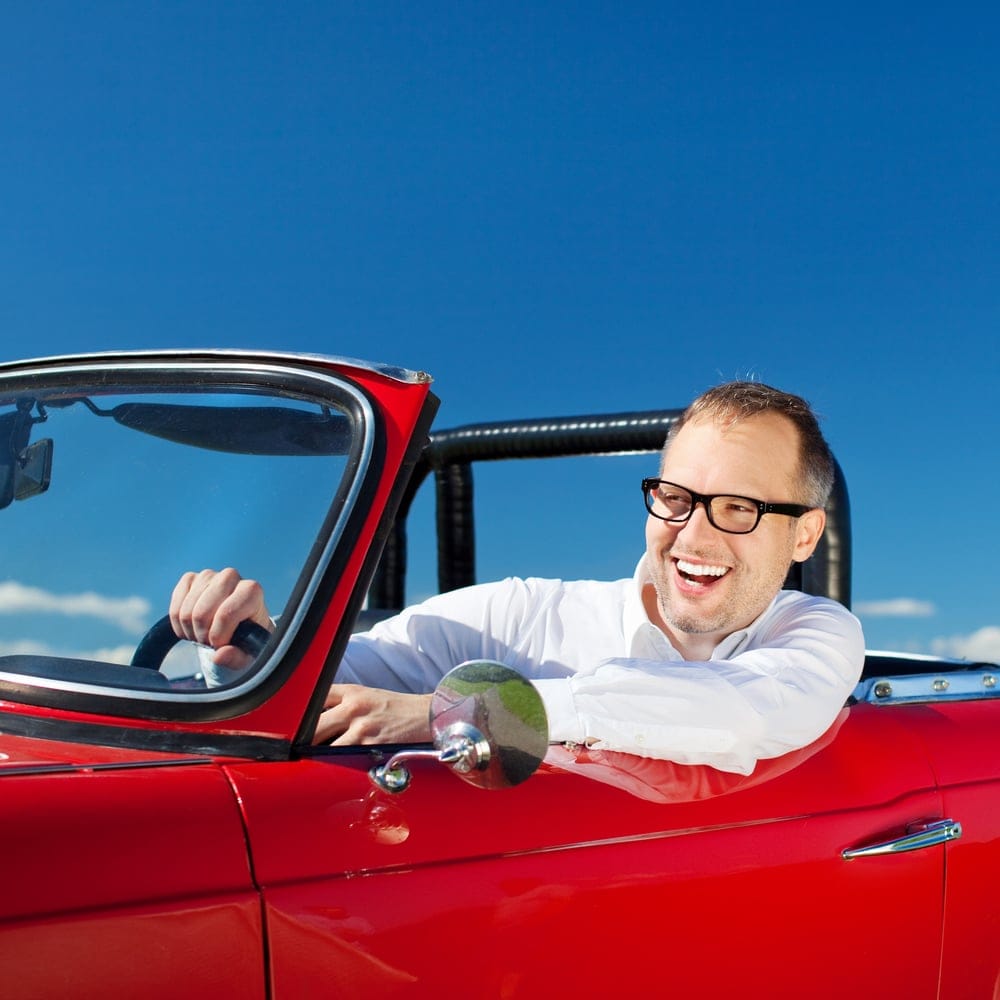 Man in a cool red convertible.