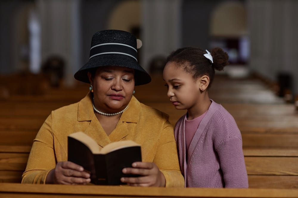 Grandmother reading bible to her granddaughter.