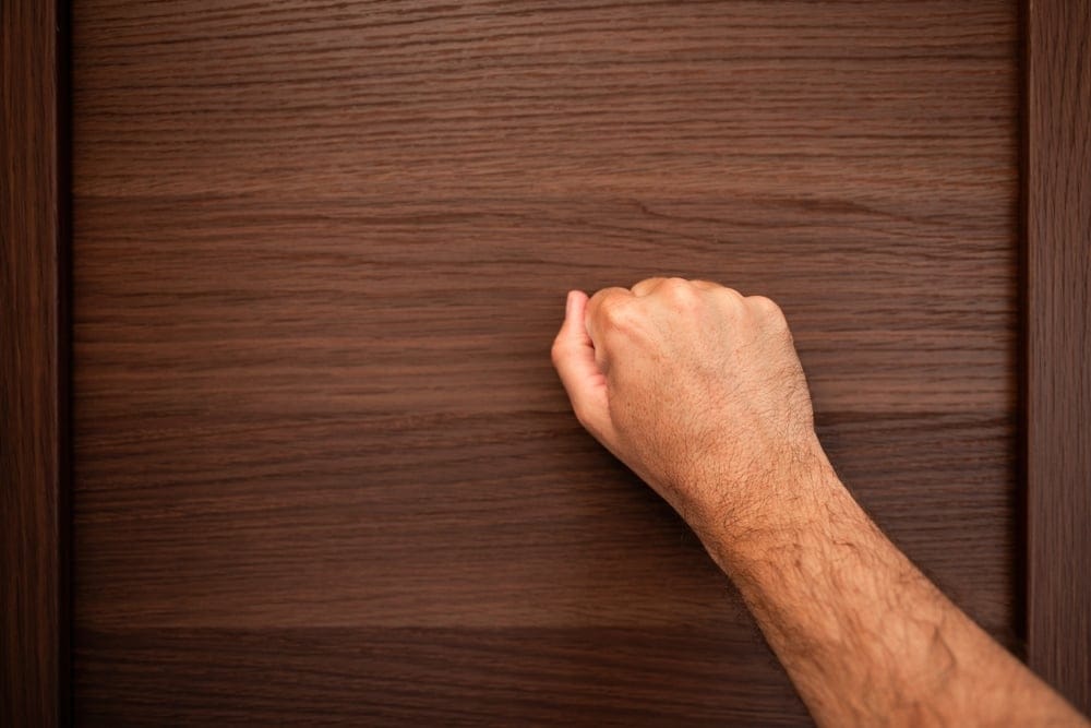 A man knocking on wood.