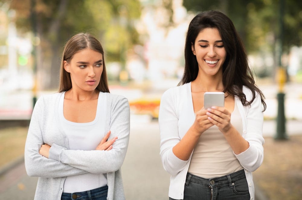 Two women walking on the street together.
