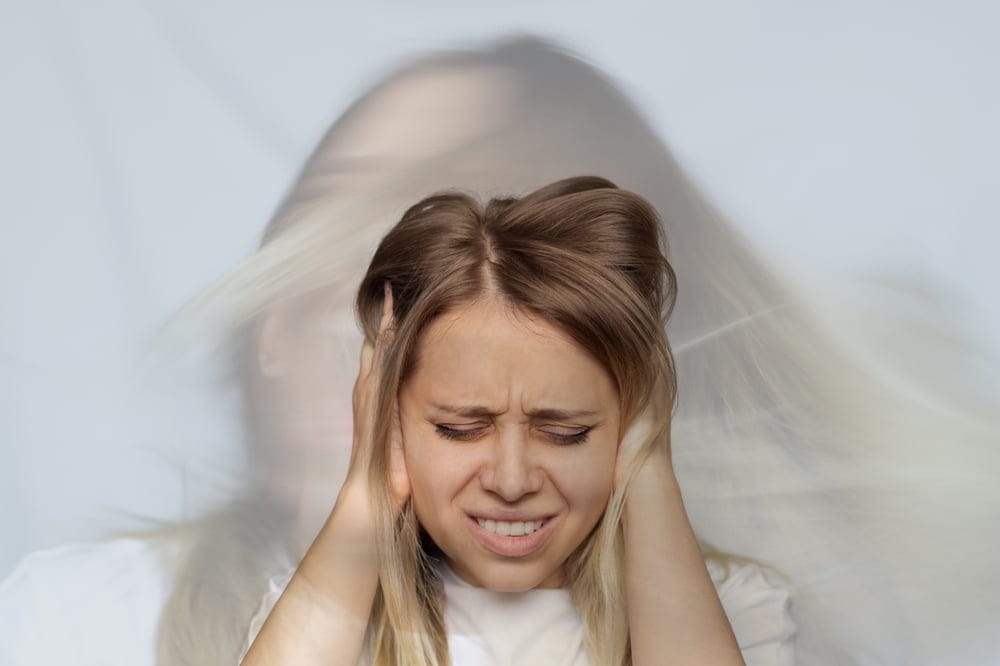 Young,Blonde,Woman,Holds,Her,Head,And,Covers,Her,Ears