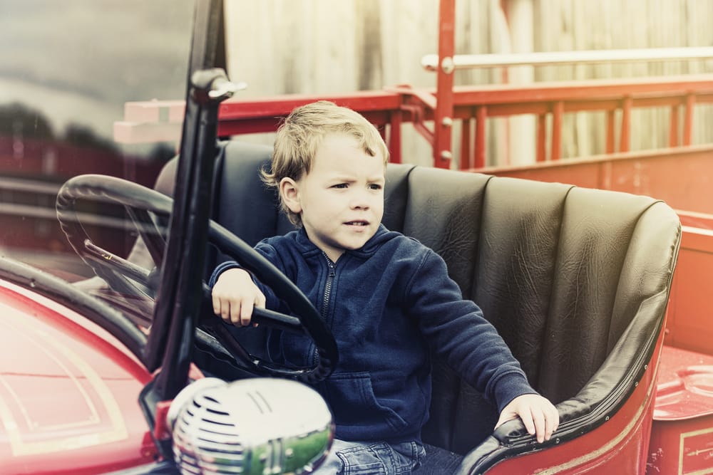 A,Happy,Young,Boy,Sits,In,An,Old,Shiny,Vintage
