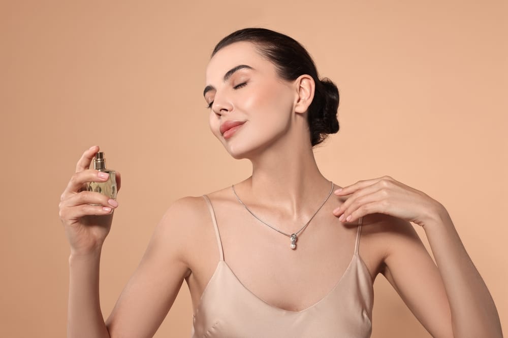Woman applying perfume.