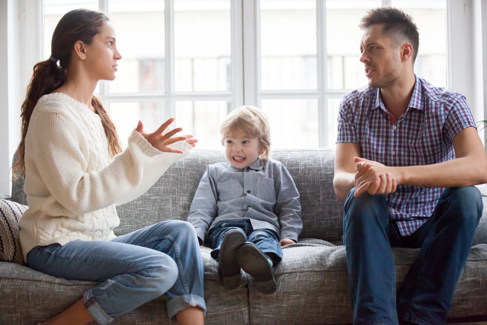 Man and wife arguing in front of child.