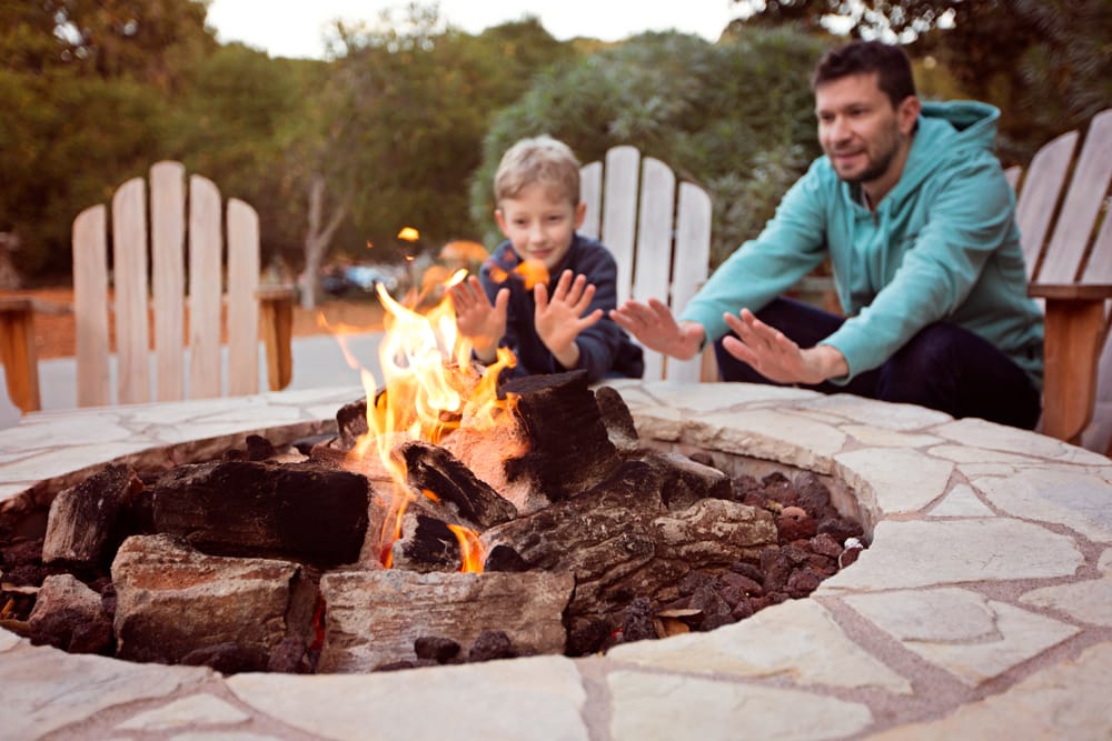 Family sitting at an outdoor fire.