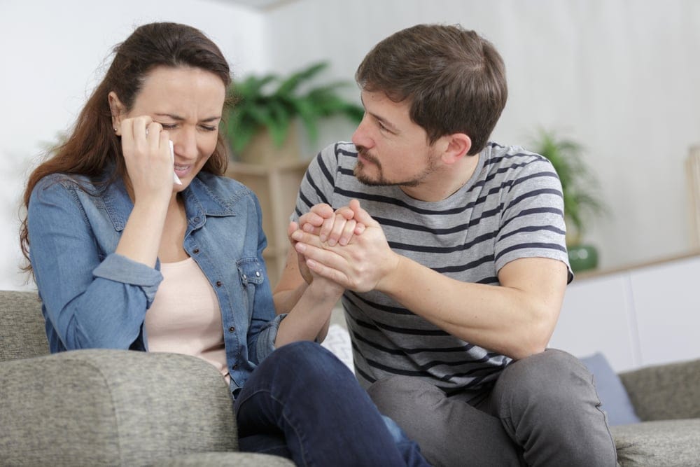 Young couple comforting one another.