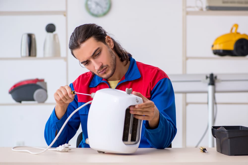 Man repairing a toaster.