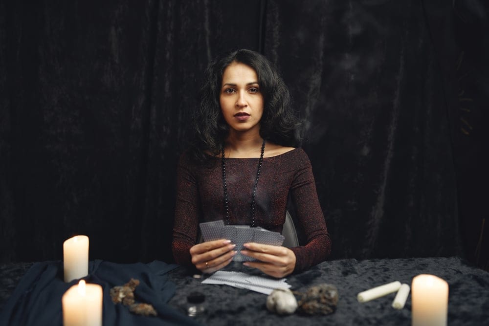 Woman reading another's fortune on cards.