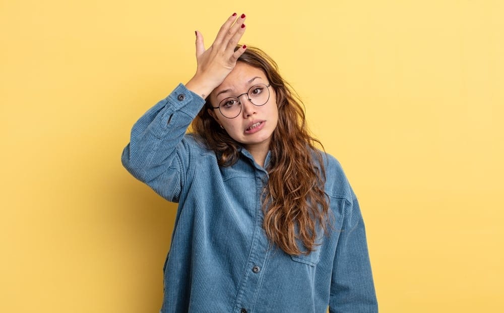 Woman with her hand on her head expressing oops.