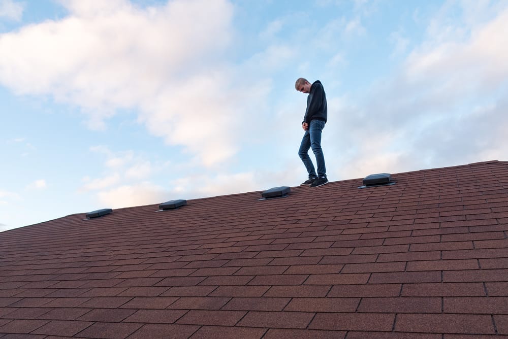 Teen standing on a roof.