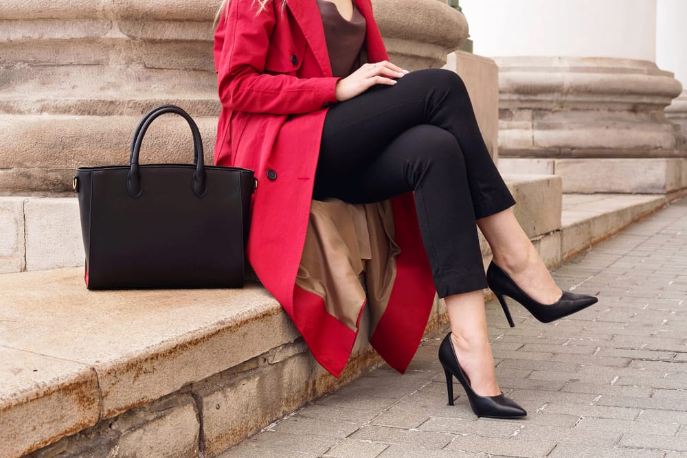 Woman sitting in black high heels.