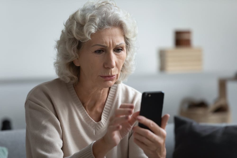 Woman looking worried on her iPhone.