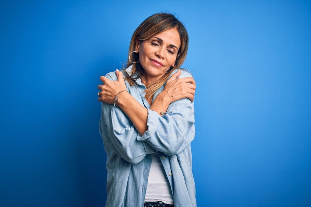 Woman giving herself a hug.