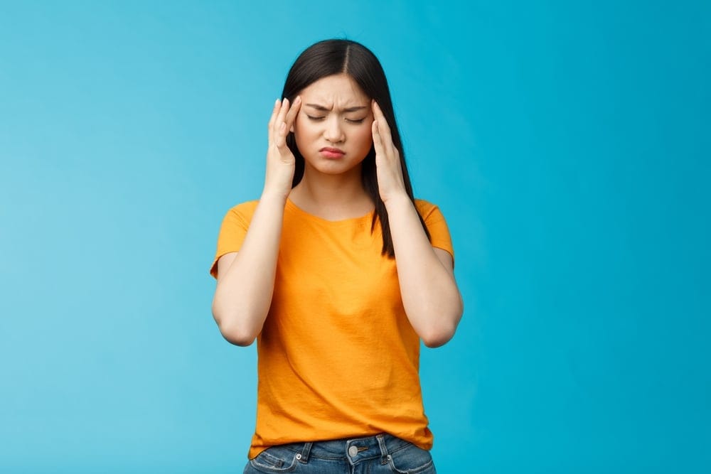 Woman looking stressed with her hands on her head.