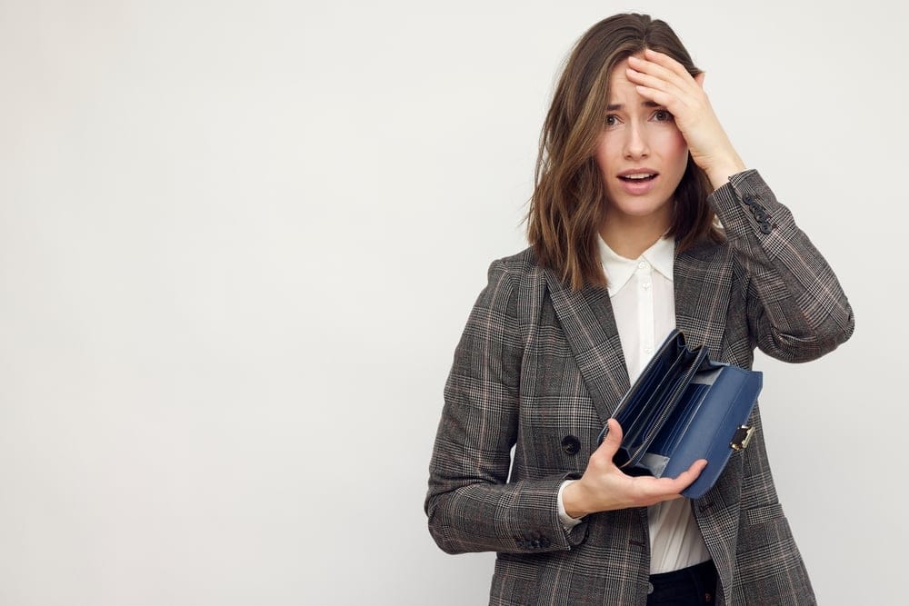 Woman dismayed at her empty wallet.