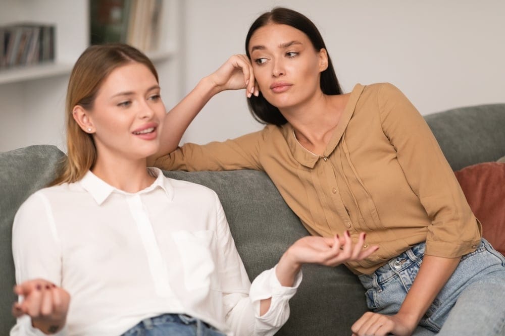 Women on a couch discussing something.