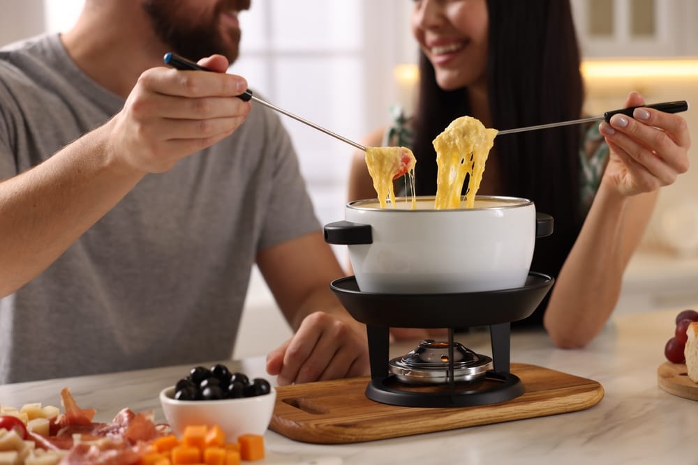 Couple enjoying cheese fondue.