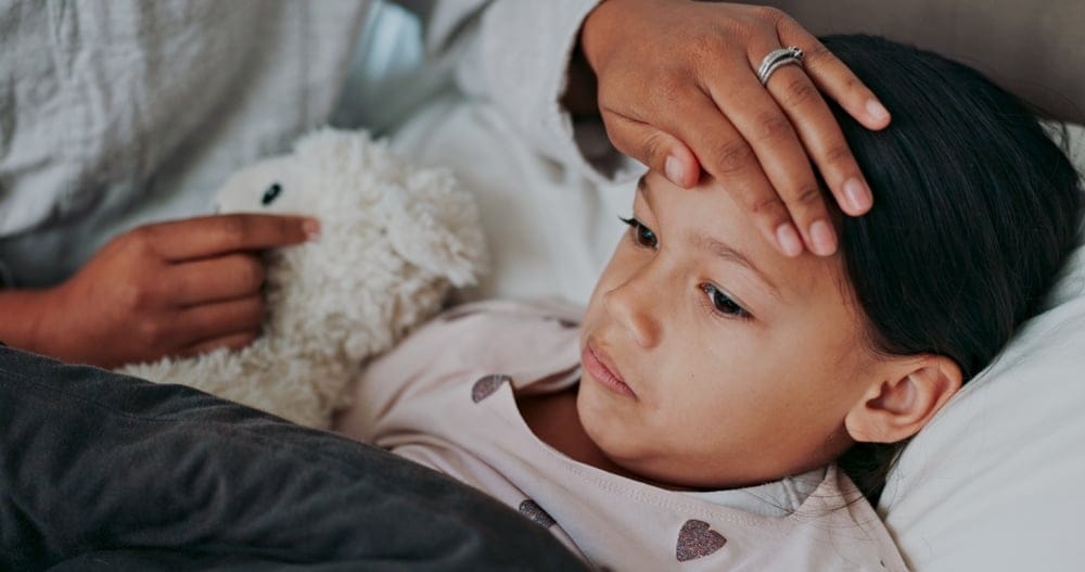 Mother feeling for a fever on her child.