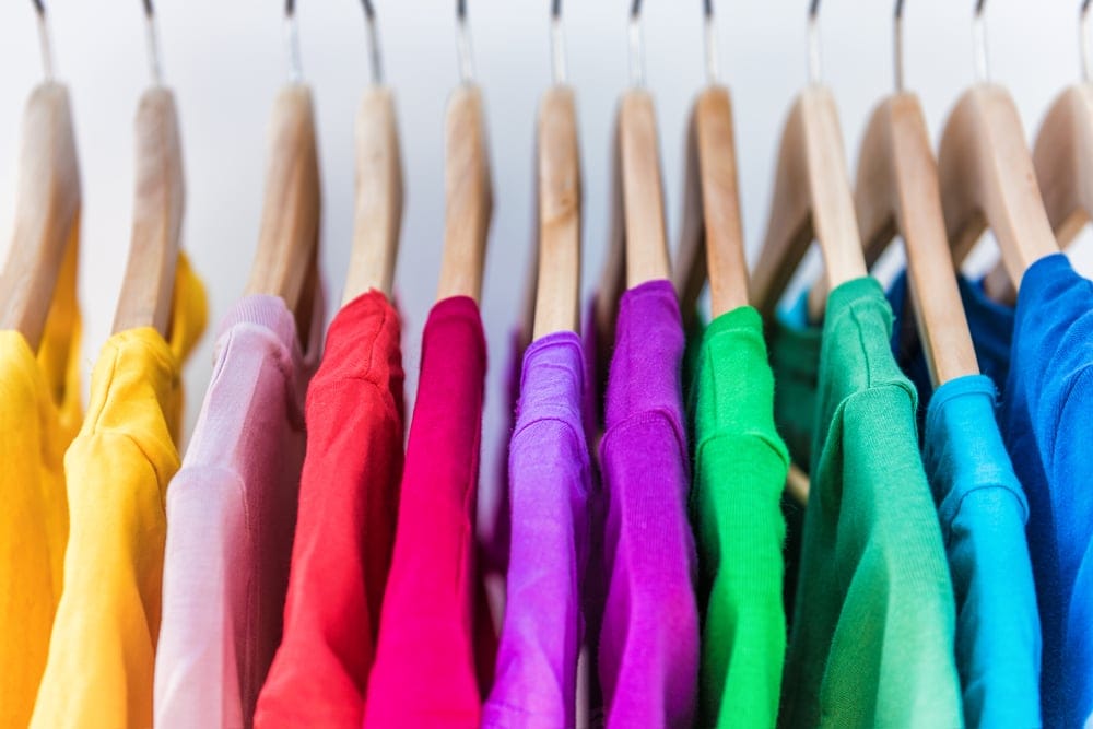 Colorful clothing hanging on a rack.