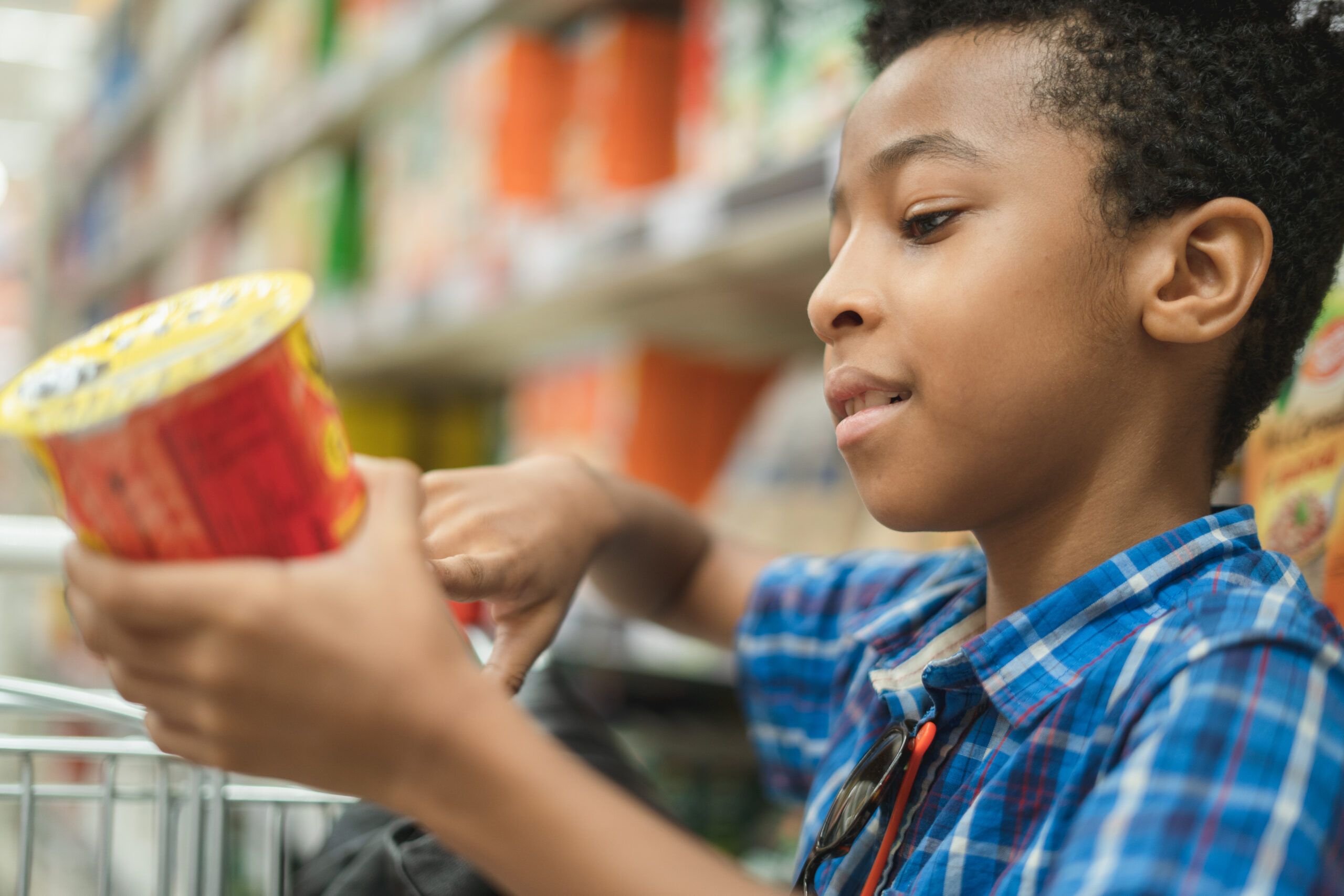 Young boy reading food label.