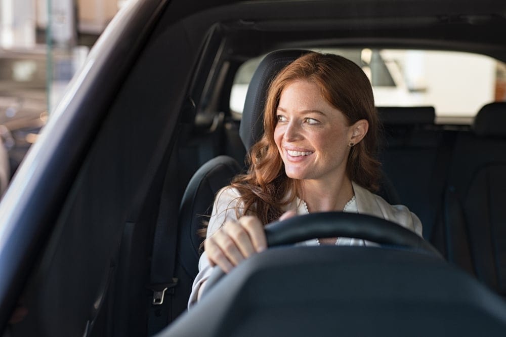 Woman behind the wheel of a car.