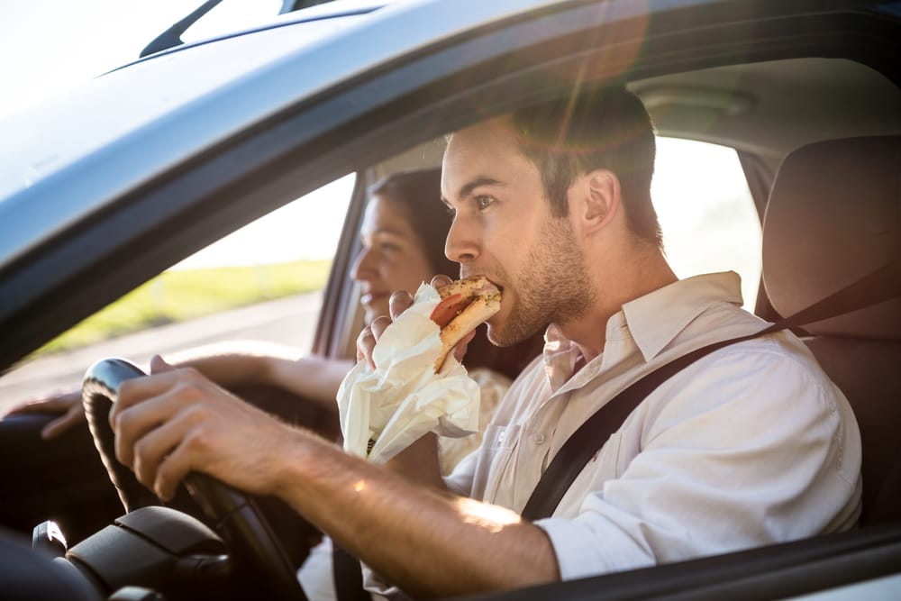 Couple in car eating fast food.