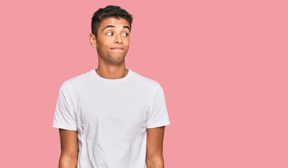 Man wearing a t-shirt looking uncomfortable.