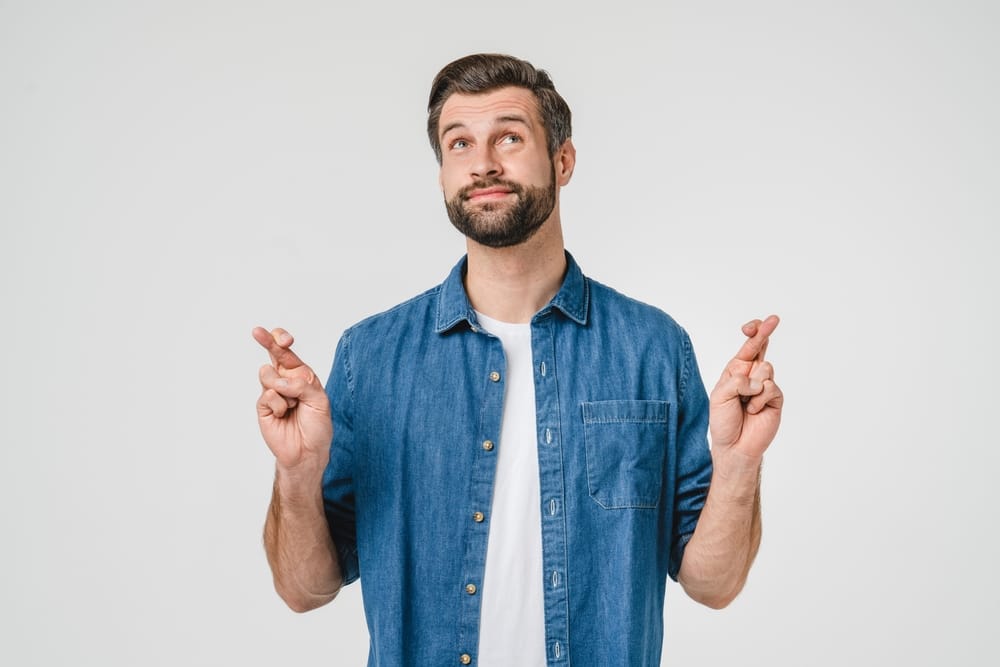 Man crossing both his fingers.