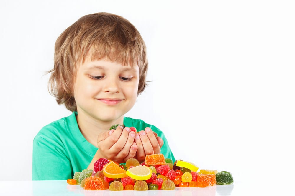 Young boy eating candy.