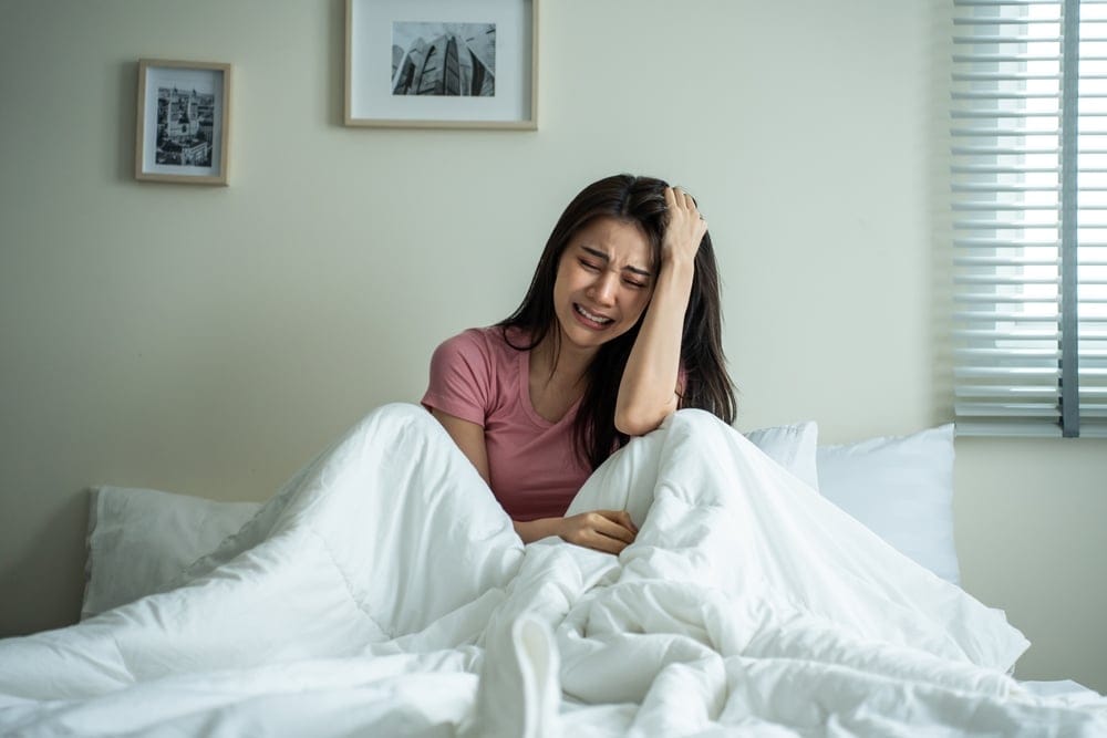 Woman crying alone in bed.