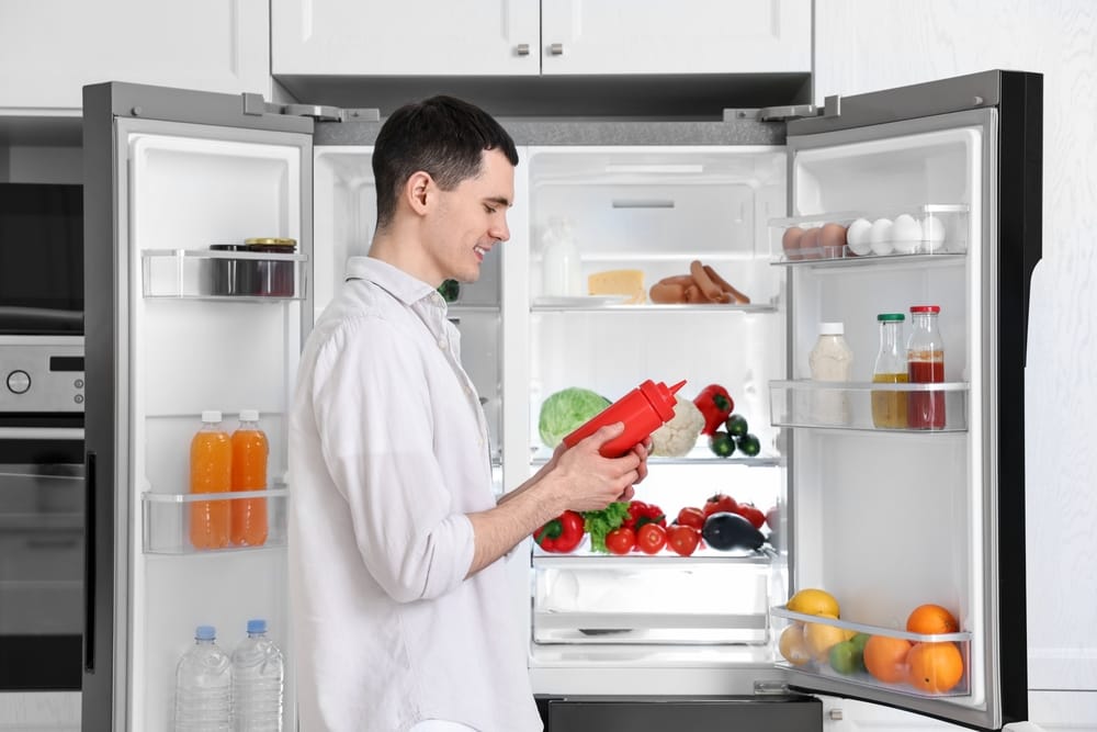 Man standing in front of refrigerator.