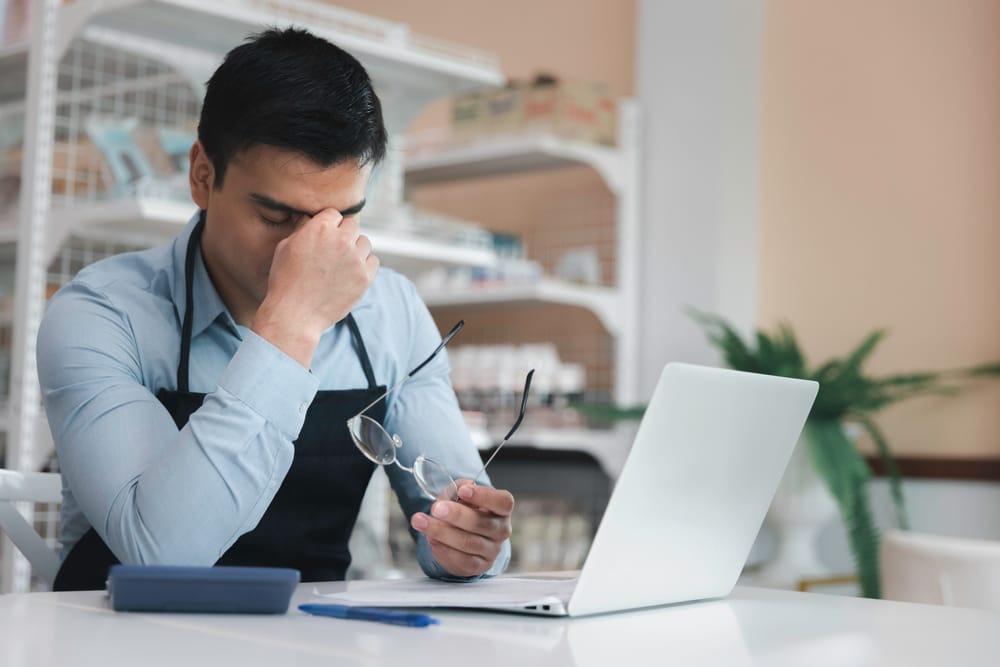 Stressed man with his head in his hand.