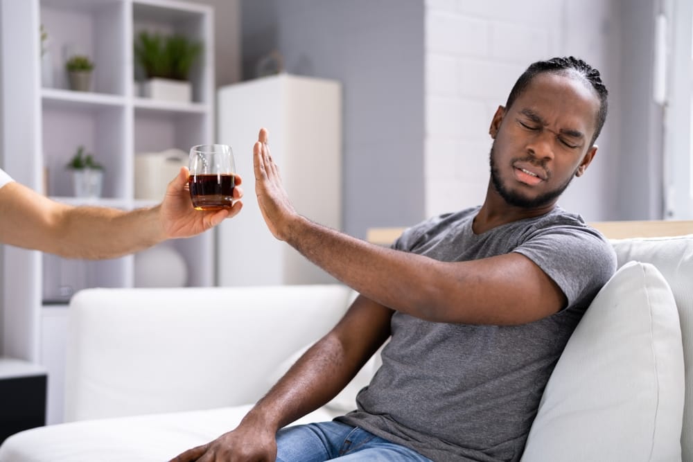 Man refusing a drink of alcohol.