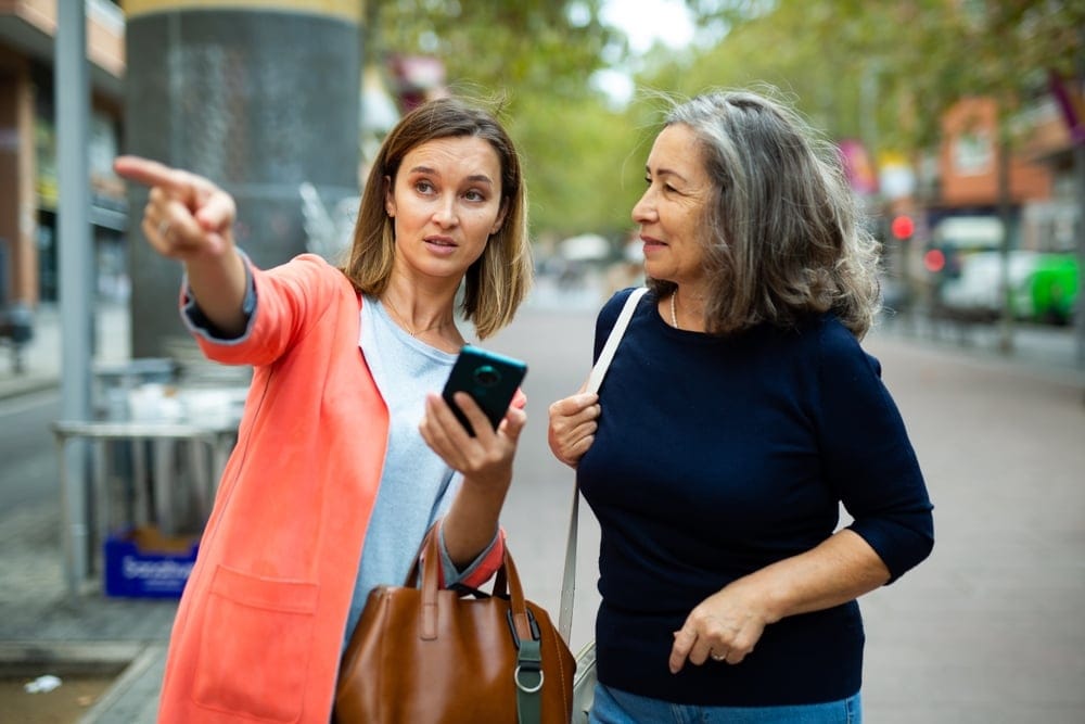 Two women walking down the street together.