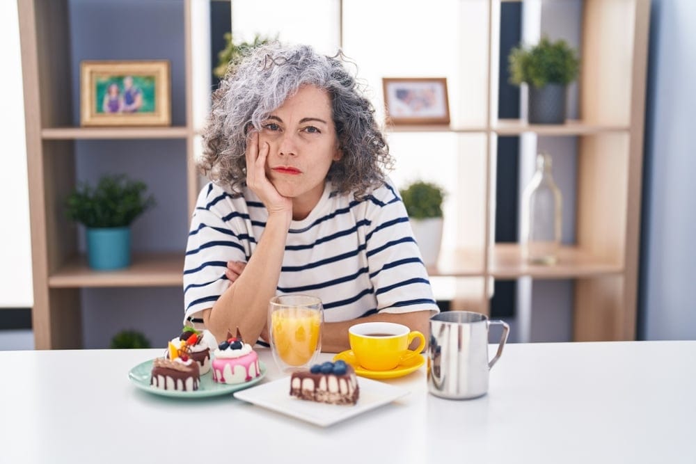 Woman with plates of food in front of her.