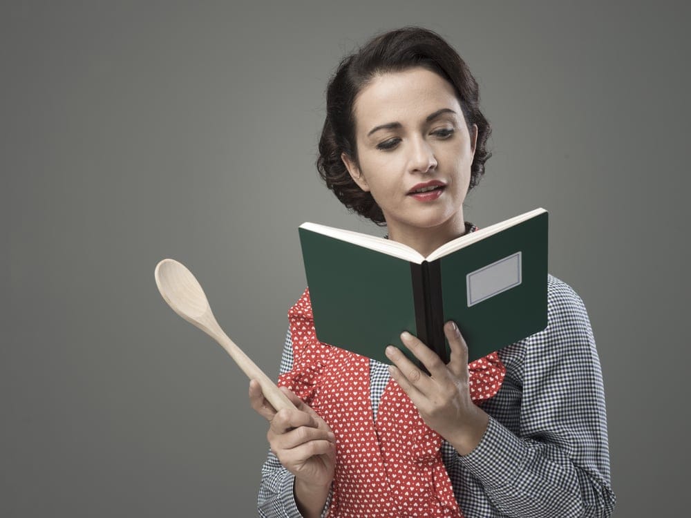 Woman looking through a cookbook.