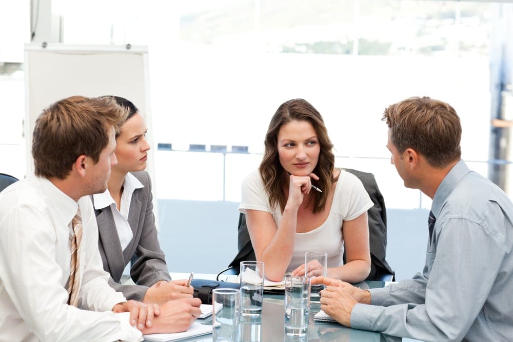 Coworkers talking around a table.