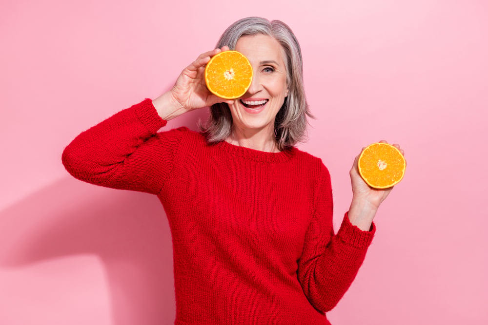 Woman holding up oranges.