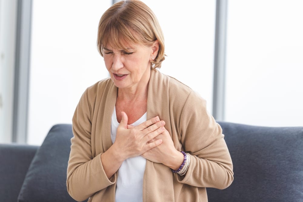 Woman with her hands over her heart.