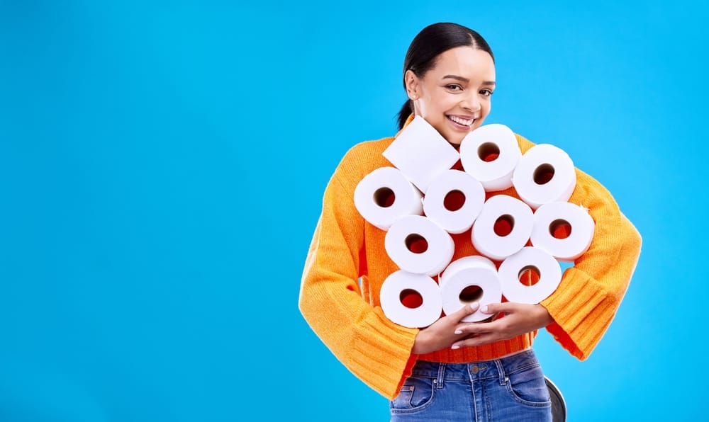 Woman holding rolls of toilet paper.
